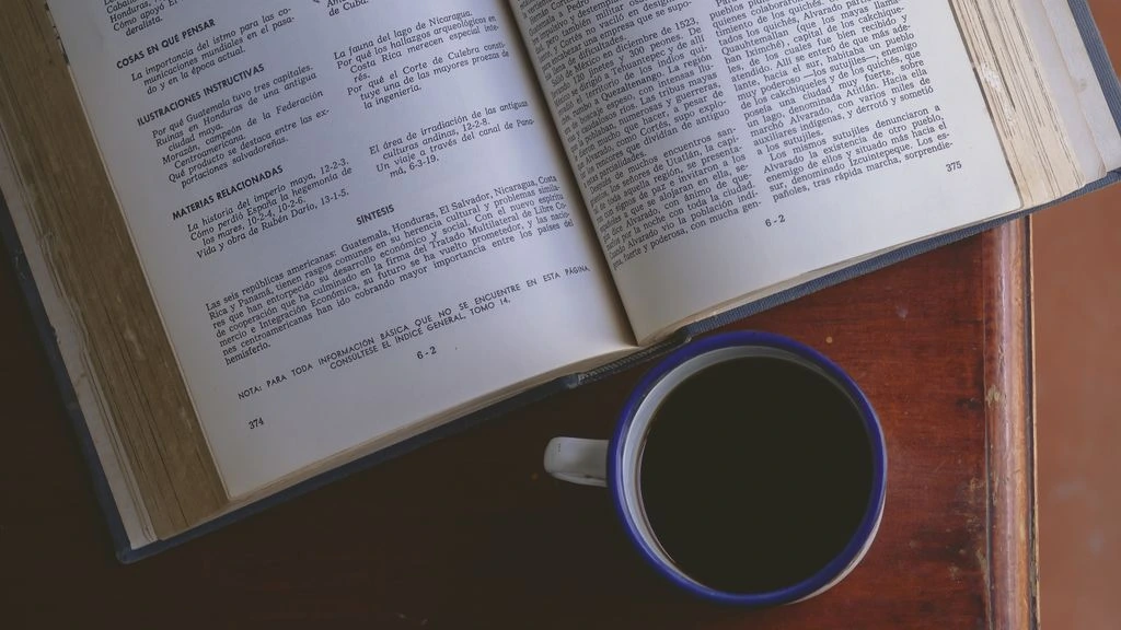 An open academic journal resting on a parchment-toned desk, signaling the editorial nature of the archive.